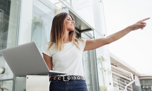 cute-woman-with-laptop-pointing-away.jpg