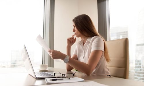 Pensive businesswoman reading document in office